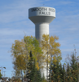Timmins Care A water tower with "Cochrane District Social Services Administration Board" written on it, surrounded by trees with autumn foliage. Cochrane District Social Services Administration Board