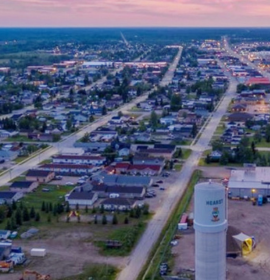 Timmins Care Aerial view of a small town in Timmins at dusk with clear skies and street lights beginning to illuminate. Cochrane District Social Services Administration Board